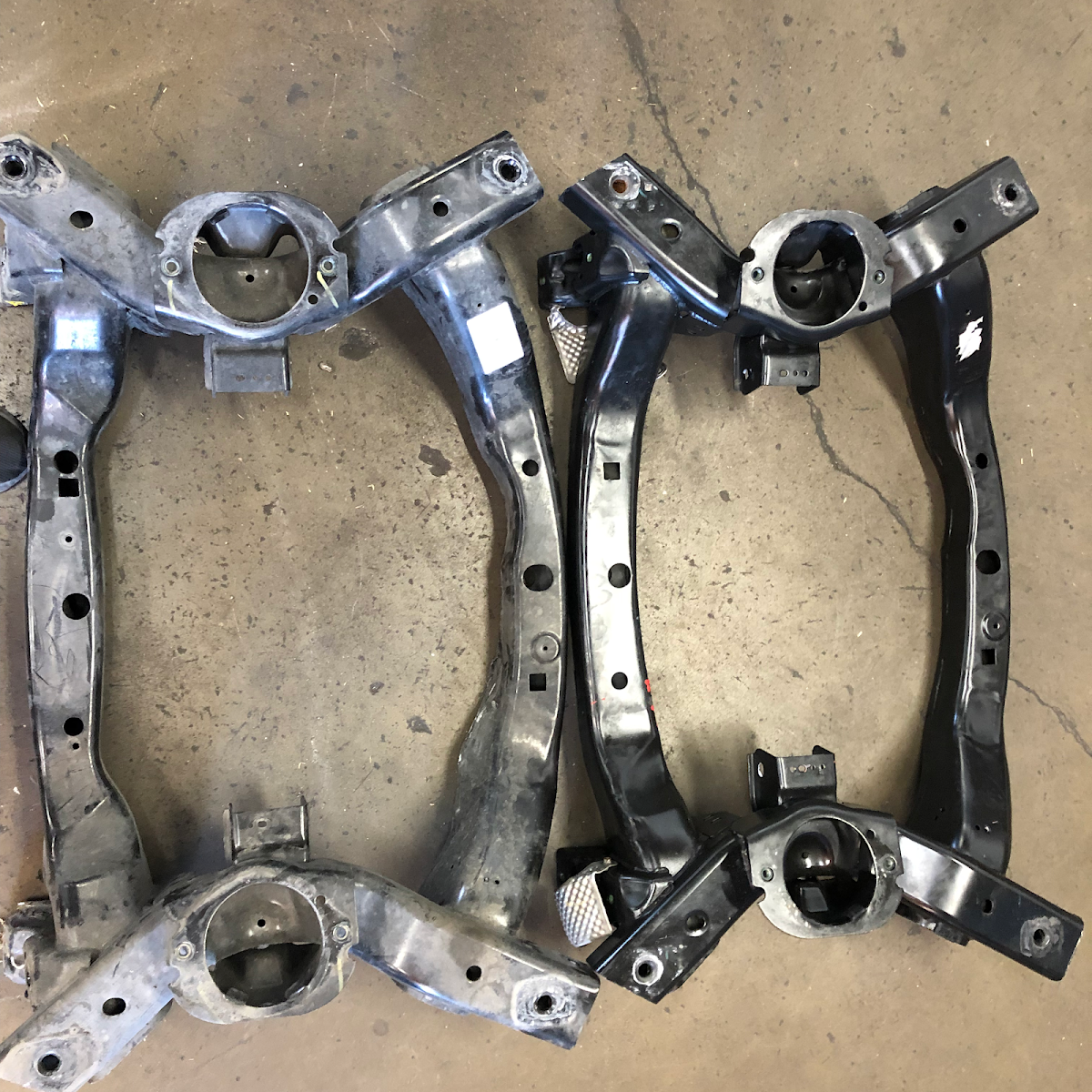 Two vehicle subframes laid out on the workshop floor